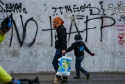 A man and a boy walk past graffiti against AFPs, Chile’s pension system, in Santiago, July 22, 2020 (AP photo by Esteban Felix).