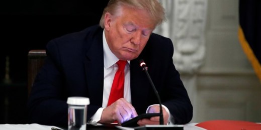 President Donald Trump looks at his phone during a roundtable with governors at the White House, Washington, June 18, 2020 (AP photo by Alex Brandon).