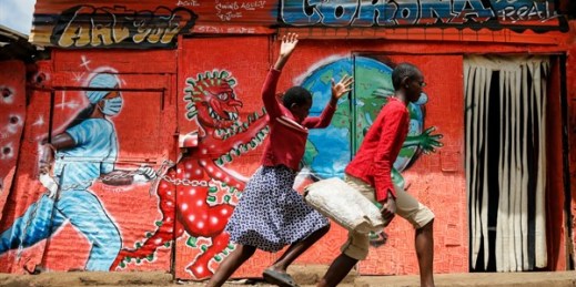 Children run down a street past a mural warning people about the dangers of the coronavirus, Nairobi, Kenya, June 3, 2020 (AP photo by Brian Inganga).