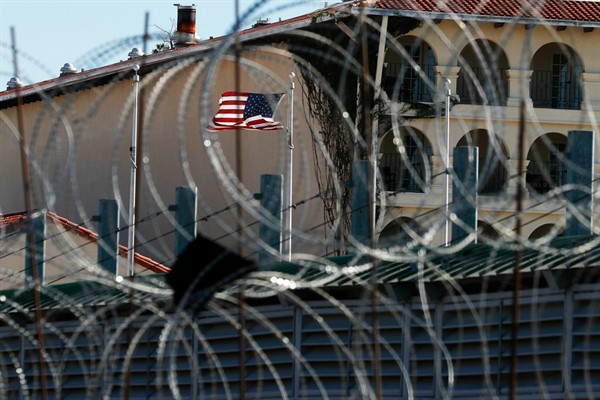 Seen through razor wire, a U.S. flag flies near the International Bridge 1 Las Americas, which connects Laredo, Texas, in the U.S. with Nuevo Laredo, Mexico, July 18, 2019 (AP photo by Marco Ugarte).