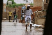 A man wades through a flooded road in the town of Shaqilab, Sudan, Aug. 31, 2020 (AP photo by Marwan Ali).