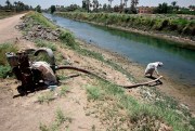 A farmer adjusts an irrigation pump in the town of Mishkhab, south of Najaf, Iraq, June 26, 2018 (AP photo by Anmar Khalil).