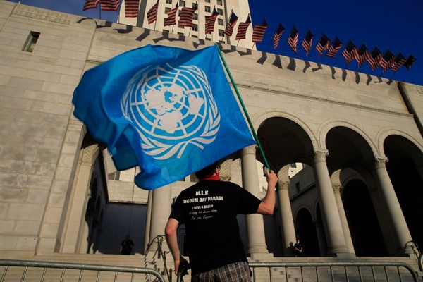 A protester holds a United Nations flag at a Black Lives Matter demonstration in Los Angeles, Calif., June 6, 2020 (AP photo by Damian Dovarganes).