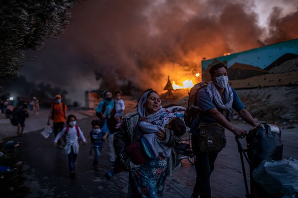 Refugees and migrants flee a fire burning at the Moria camp on Lesbos island, Greece, Sept. 9, 2020 (AP photo by Petros Giannakouris).
