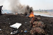 A worker burns cables and other parts of old electrical devices at the Agbogbloshie scrap yard in Accra, Ghana.