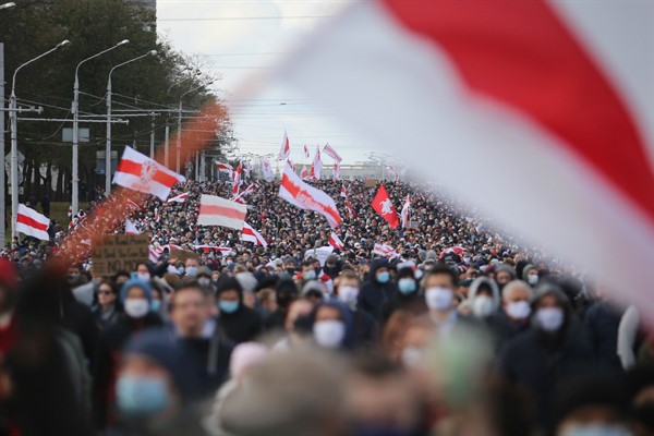 People with old Belarusian national flags march during a rally to protest the official presidential election results in Minsk, Belarus, Oct. 18, 2020 (AP photo).