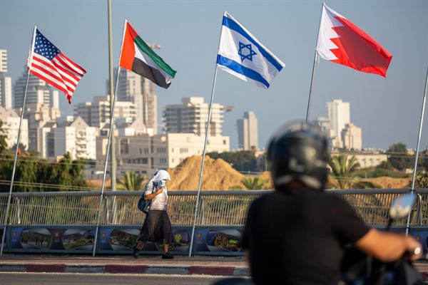 A woman walks past American, United Arab Emirates, Israeli and Bahraini flags on the Peace Bridge in Netanya, Israel, Sept. 14, 2020 (AP photo by Ariel Schalit).