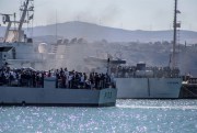 Migrants arrive in Porto Empedocle, Sicily, aboard two military ships after being transferred from the island of Lampedusa, July 27, 2020 (LaPresse photo by Fabio Peonia via AP).