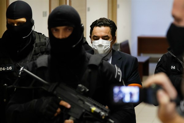 Marian Kocner, center right, is escorted by armed police officers to a courtroom for his trial, in Pezinok, Slovakia, Sept. 3, 2020 (AP photo by Petr David Josek).