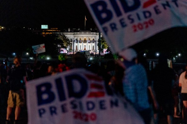 Supporters of Democratic presidential nominee Joe Biden wave banners near the White House, in Washington, Aug. 27, 2020 (AP photo by Andrew Harnik).