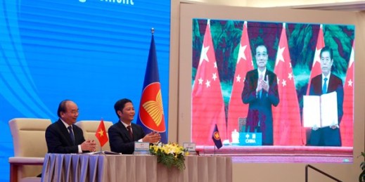 Vietnamese Prime Minister Nguyen Xuan Phuc, left, and Minister of Trade Tran Tuan Anh, right, next to a screen showing Chinese Premier Li Keqiang and Minister of Commerce Zhong Shan, during the RCEP signing ceremony, Hanoi, Vietnam (AP photo by Hau Dinh).