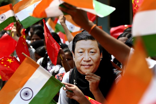 An Indian schoolgirl wears a mask of Chinese leader Xi Jinping to welcome him on the eve of his visit to Chennai, India, Oct. 10, 2019 (AP photo by R. Parthibhan).
