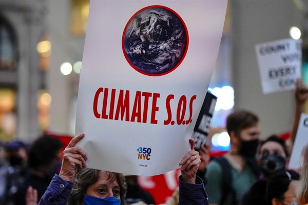 A demonstrator holds a “Climate SOS” sign during a post-election march in New York City, Nov. 4, 2020 (Photo by John Nacion for STAR MAX/IPx via AP Images).