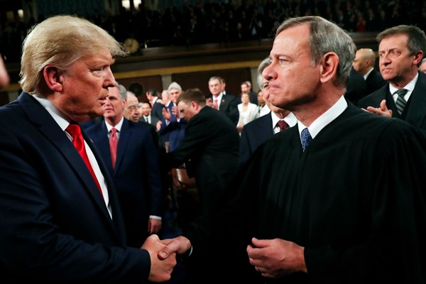 President Donald Trump greets Supreme Court Chief Justice John Roberts before delivering his State of the Union address, in Washington, Feb. 4, 2020 (Pool photo by Leah Millis via AP Images).