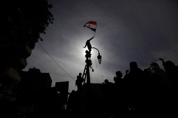 An Egyptian protester waves the national flag during a demonstration in Tahrir Square, Cairo, Egypt, Feb. 3, 2012 (AP photo by Nathalie Bardou).