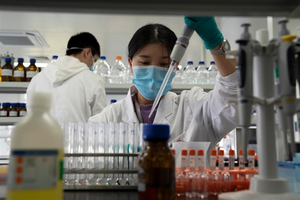 An employee of Chinese pharmaceutical giant Sinovac works in a lab at a factory producing its vaccine for COVID-19, Beijing, Sept. 24, 2020 (AP photo by Ng Han Guan).