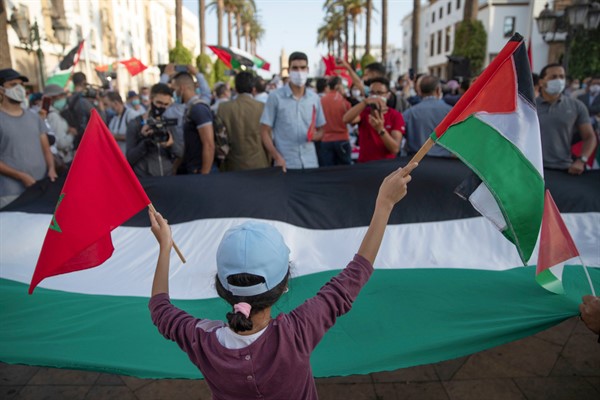 A young girl waves a Moroccan and a Palestinian flag during a protest against normalizing relations with Israel, in Rabat, Morocco, Sept. 18, 2020 (AP photo by Mosa’ab Elshamy).