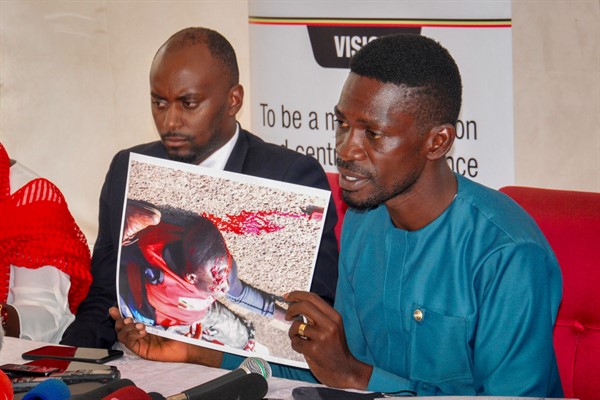 Ugandan presidential candidate Bobi Wine shows a photograph depicting a victim of recent electoral violence, at the Electoral Commission in Kampala, Uganda, Dec. 2, 2020 (AP photo by Ronald Kabuubi).