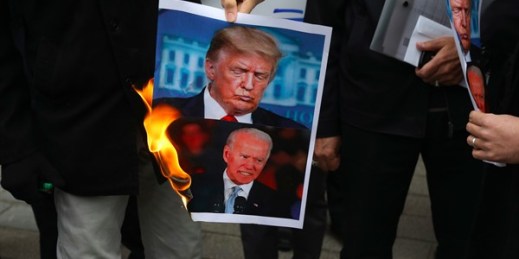 Protesters burn pictures of U.S. President Donald Trump and President-elect Joe Biden outside the Iranian Foreign Ministry, Tehran, Nov. 28, 2020 (AP photo by Vahid Salemi).