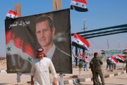 A poster of Syrian President Bashar Assad with Arabic that reads, "Congratulations victory," at the border crossing between the Iraqi town of Qaim and Boukamal, Syria, Sept. 30, 2019 (AP photo by Hadi Mizban).