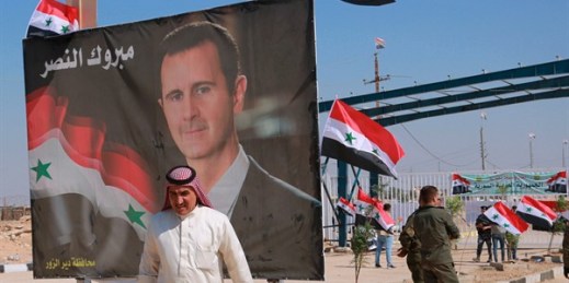A poster of Syrian President Bashar Assad with Arabic that reads, "Congratulations victory," at the border crossing between the Iraqi town of Qaim and Boukamal, Syria, Sept. 30, 2019 (AP photo by Hadi Mizban).