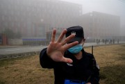 A security person moves journalists away from the Wuhan Institute of Virology after a World Health Organization team arrived for a field visit in Wuhan, China, Feb. 3, 2021 (AP photo by Ng Han Guan).