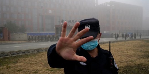 A security person moves journalists away from the Wuhan Institute of Virology after a World Health Organization team arrived for a field visit in Wuhan, China, Feb. 3, 2021 (AP photo by Ng Han Guan).
