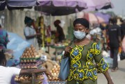 A woman walks by a market in Lagos, Nigeria, Dec. 31, 2020 (AP photo by Sunday Alamba).