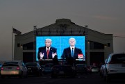 People watch then-President Donald Trump, on left of video screen, and Democratic presidential candidate Joe Biden speak during a presidential debate watch party, San Francisco, Oct. 22, 2020 (AP photo by Jeff Chiu).