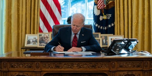 President Joe Biden signs a series of executive orders in the Oval Office of the White House, Washington, Jan. 28, 2021 (AP photo by Evan Vucci).