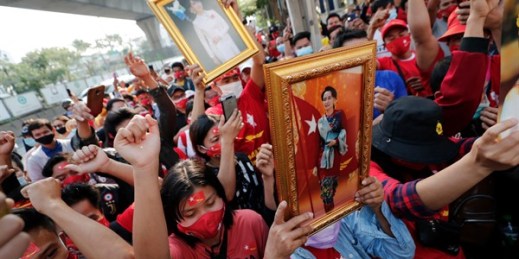 Burmese living in Thailand hold pictures of Myanmar leader Aung San Suu Kyi during a protest in front of the Myanmar Embassy, in Bangkok, Thailand, Feb. 1, 2021 (AP photo by Sakchai Lalit).
