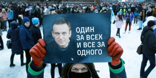 A man holds a poster in support of opposition leader Alexei Navalny that reads, “One for all and all for one,” during a protest against the Navalny’s arrest, St. Petersburg, Russia, Jan. 23, 2021 (AP photo by Dmitri Lovetsky).