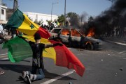 A demonstrator holds a Senegalese flag during protests against the arrest of opposition leader and former presidential candidate Ousmane Sonko, in Dakar, Senegal, March 8, 2021 (AP photo by Leo Correa).