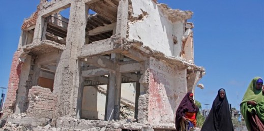 Somali women walk past a destroyed building after a suicide car bomb attack in Mogadishu, Somalia, May 22, 2019 (AP photo by Farah Abdi Warsameh).