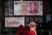 A bank window panel displaying the security markers on the latest 100 Yuan notes in Beijing, China, Feb. 18, 2019 (AP photo by Andy Wong).
