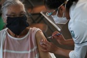 An elderly woman gets her shot of the Pfizer vaccine for COVID-19 in Mexico City, March 8, 2021 (AP photo by Marco Ugarte).
