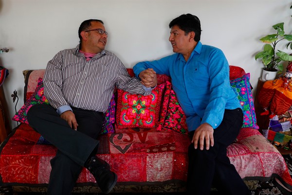 Guido Montano, left, and his partner, David Aruquipa, kiss during a press conference in La Paz, Bolivia, Dec. 11, 2020 (AP photo by Juan Karita).