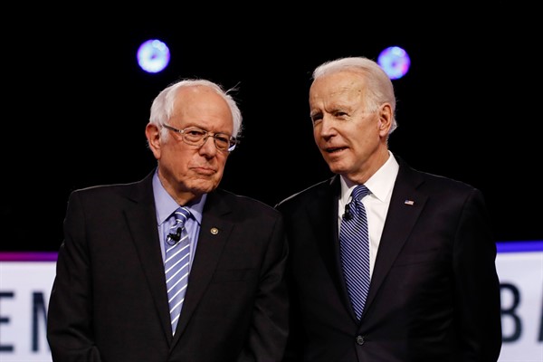 Sen. Bernie Sanders, left, and Joe Biden talk before a Democratic presidential primary debate in Charleston, South Carolina, Feb. 25, 2020 (AP photo by Matt Rourke).