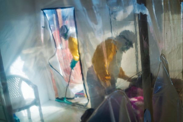 Health workers tend to an Ebola victim kept in an isolation cube in Beni, Congo, July 13, 2019 (AP photo by Jerome Delay).
