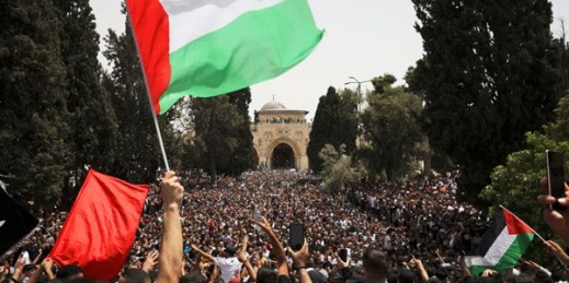Palestinians wave national flags at al-Aqsa mosque complex in Jerusalem, May 21, 2021 (AP photo by Mahmoud Illean).
