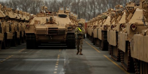 A U.S. soldier walks past parked armored vehicles and tanks of the 1st Armored Brigade Combat Team and 1st Calvary Division, based out of Fort Hood, Texas, as they are unloaded in Antwerp, Belgium, Nov. 16, 2020 (AP photo by Francisco Seco).