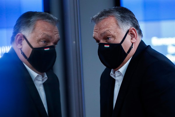 Hungary’s prime minister, Viktor Orban, is reflected in glass as he leaves at the end of an EU summit in Brussels, Dec. 11, 2020 (AP photo by Francisco Seco).