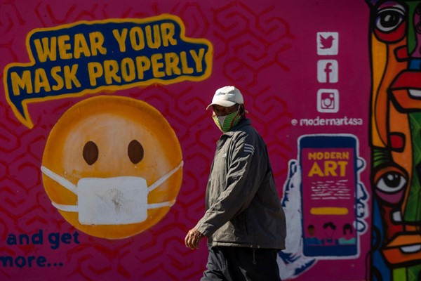 A man walks past a mural on how to wear a face mask to prevent the spread of coronavirus, in Soweto, South Africa, May 15, 2021 (AP photo by Themba Hadebe).