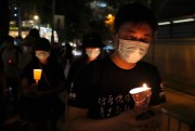People walk with candles to mark the anniversary of the Tiananmen Square massacre, outside Victoria Park in Hong Kong, June 4, 2021 (AP photo by Kin Cheung).