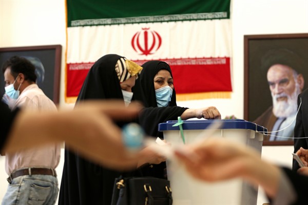 An Iranian woman casts her vote at a polling station inside the Iranian consulate in Karbala, Iraq, June 18, 2021 (AP photo by Hadi Mizban).