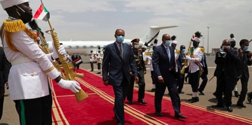 Eritrean President Isaias Afwerki, center, with Gen. Abdel Fattah al-Burhan, president of the Sudanese Transitional Council, at the Khartoum airport in Sudan, May 4, 2021 (AP photo by Marwan Ali).