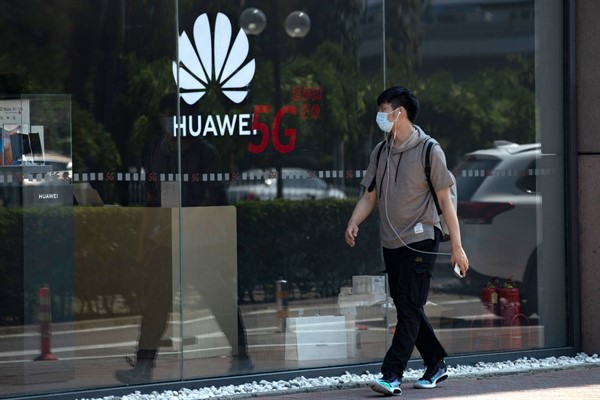 A man walks past a Huawei store promoting 5G technologies in Beijing, China, July 15, 2020 (AP photo by Ng Han Guan).