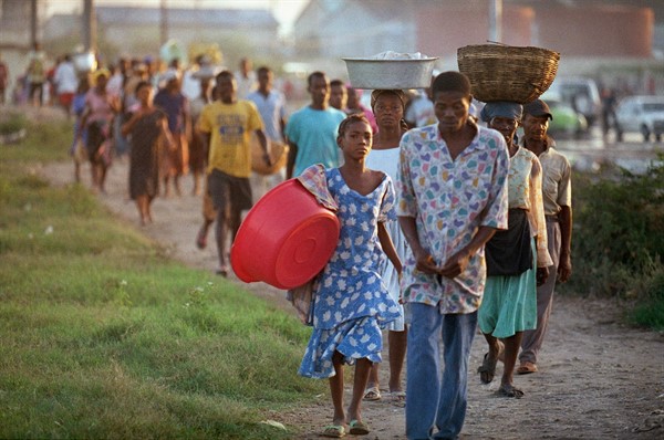 Residents of the Port-au-Prince slum Cite Soleil make their way to the downtown market by foot due to an oil embargo, Oct. 26, 1993 (AP photo by Michael Stravato).