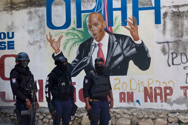 Police stand near a mural featuring Haitian President Jovenel Moise, near the leader’s residence where he was killed by gunmen, in Port-au-Prince, Haiti, July 7, 2021 (AP photo by Joseph Odelyn).