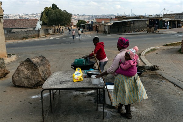 Women pack up their roadside food stall in Alexandra Township, north of Johannesburg, South Africa, July 15 2021 (AP photo by Ali Greeff).
